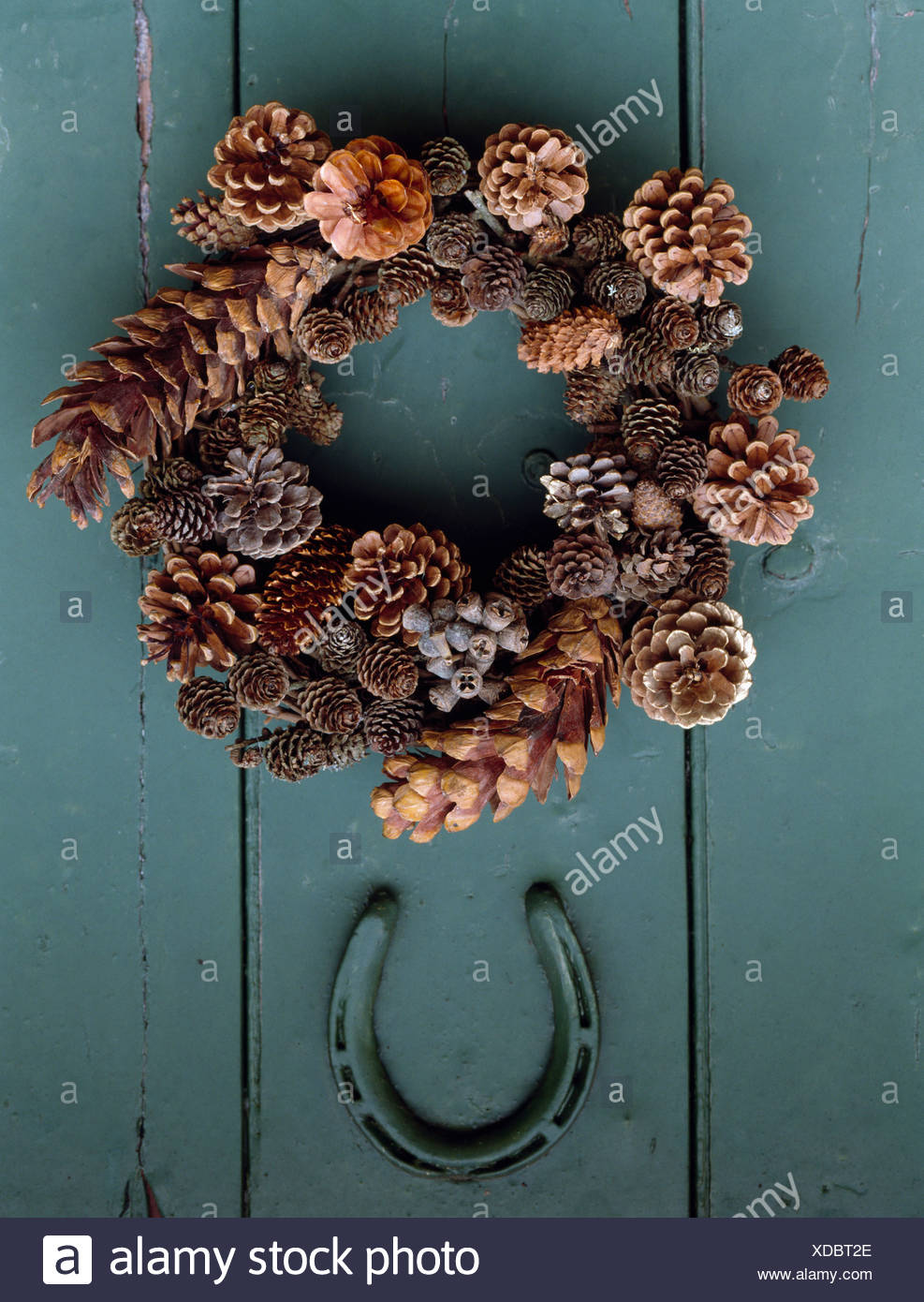 close up of home made pine cone wreath and old horseshoe on grey green painted door - Horseshoe Christmas Wreath close up of home made pine cone wreath and old horseshoe on grey green painted door - Horseshoe Christmas Wreath