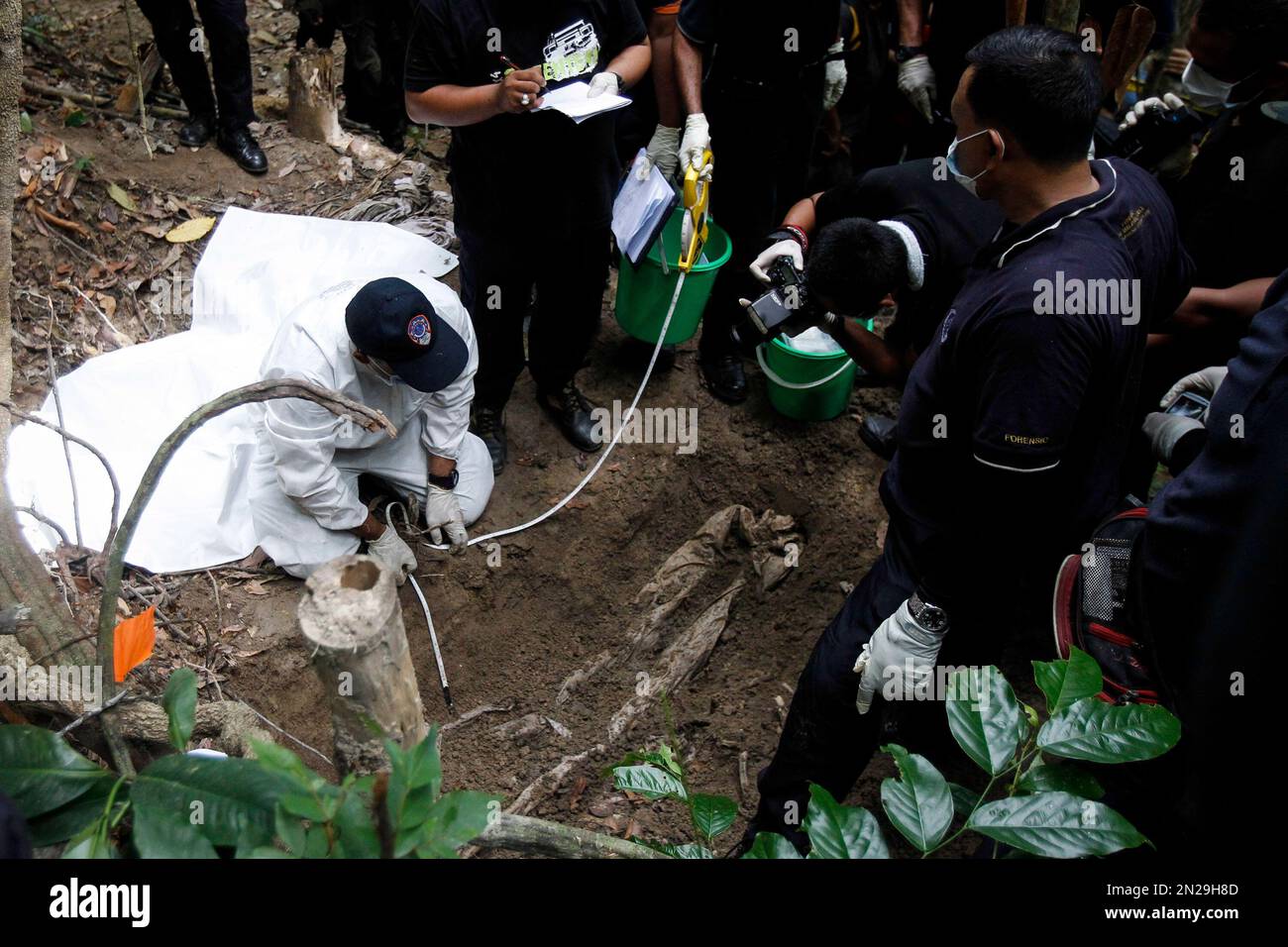 Malaysian Police Forensic Team Members Inspect A Freshly Exhumed Human