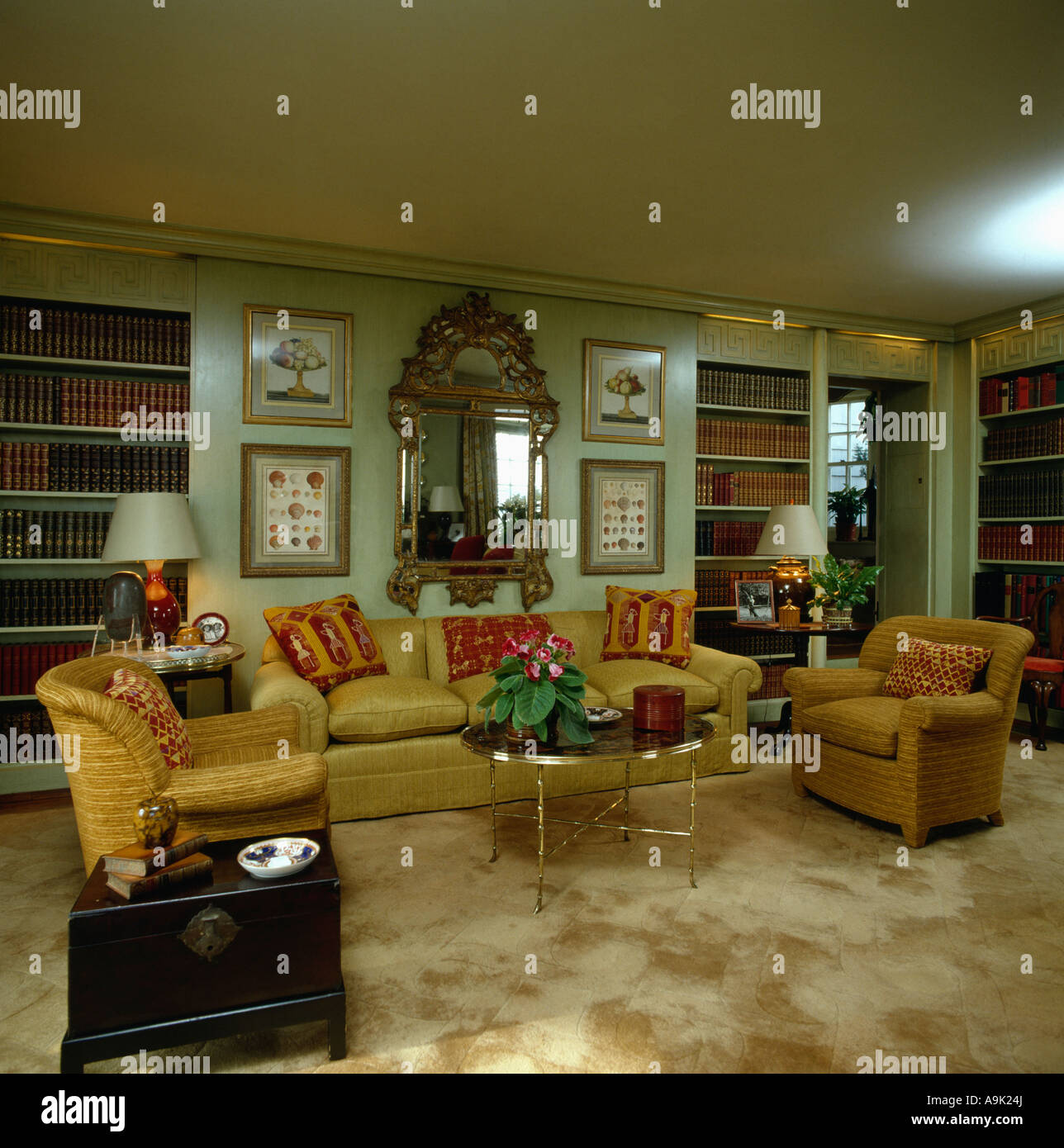 Verzierten goldgerahmten Spiegel über dem gelben Sofa und Sesseln in ... Verzierten goldgerahmten Spiegel über dem gelben Sofa und Sesseln in ...