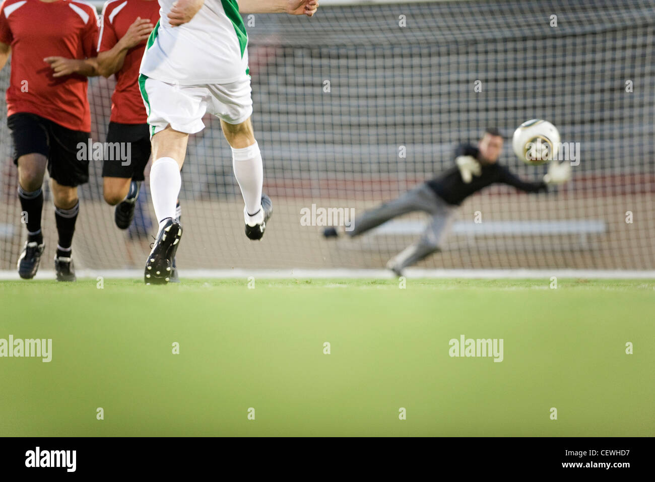 Fußball Spieler schießen auf das Tor, beschnitten Stockfoto, Bild