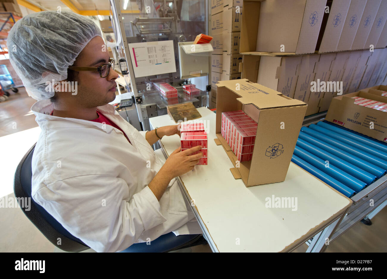Ein Mitarbeiter der Firma Weleda Naturkosmetik packt