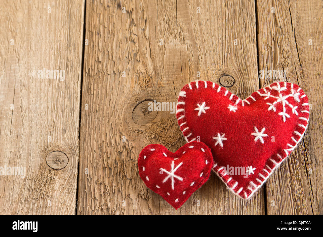 Weihnachten-Konzept (Dekoration). Zwei rote handgefertigte Herzen über