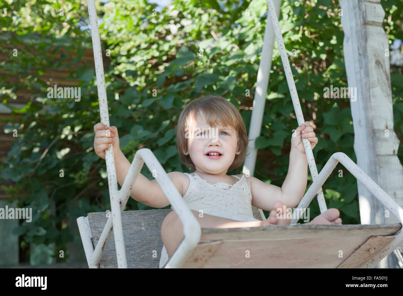 Lachende Mädchen auf der Schaukel im Sommerpark Stockfotografie Alamy