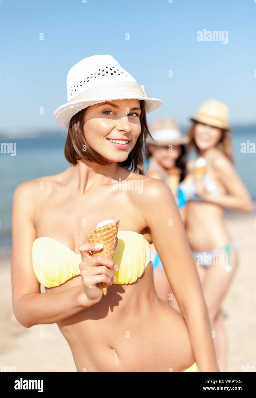 Mädchen im Bikini am Strand Eis essen Stockfotografie Alamy