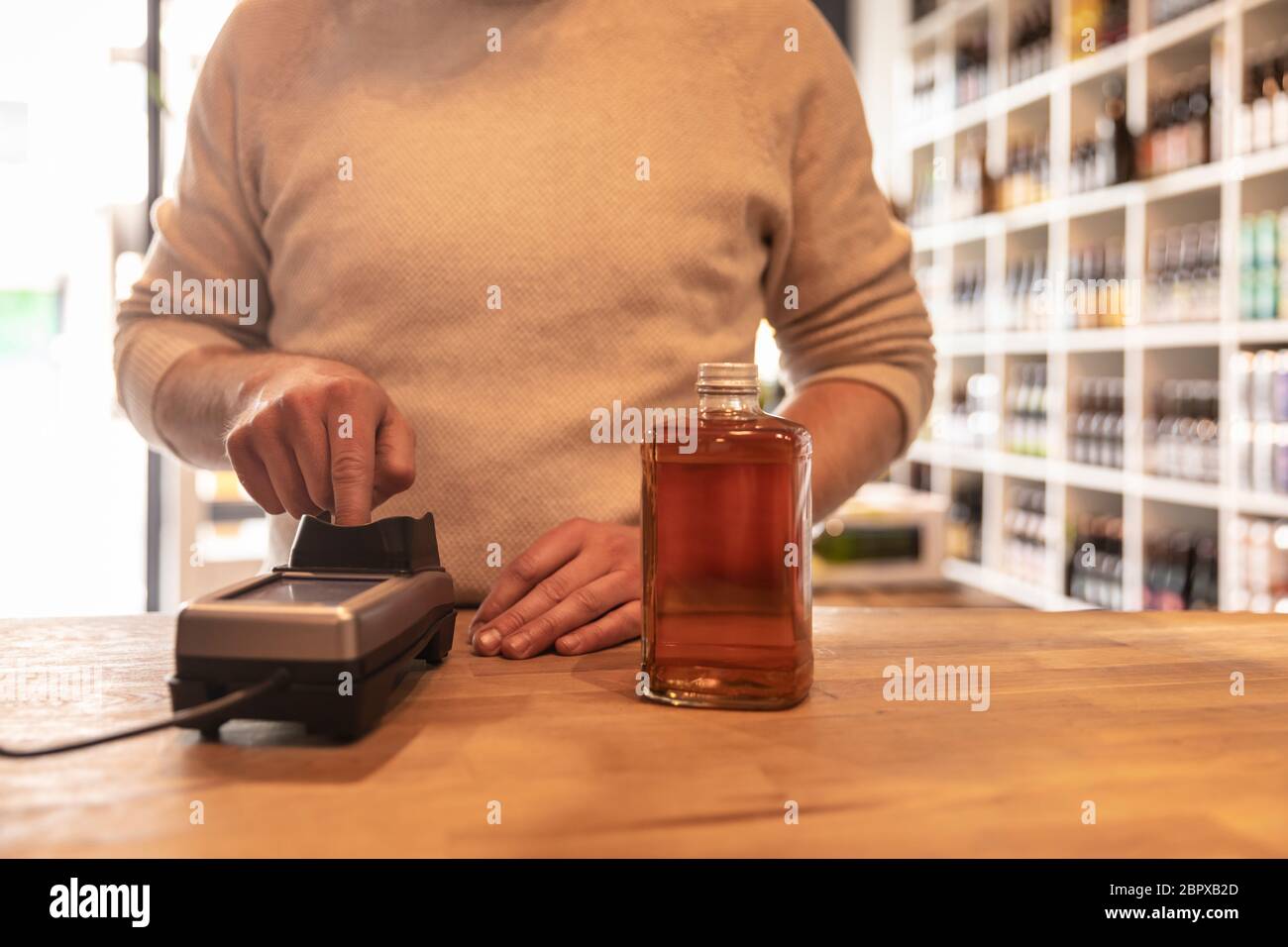 Un Hombre Que Paga Por Una Botella De Alcohol En Una Tienda De Licores