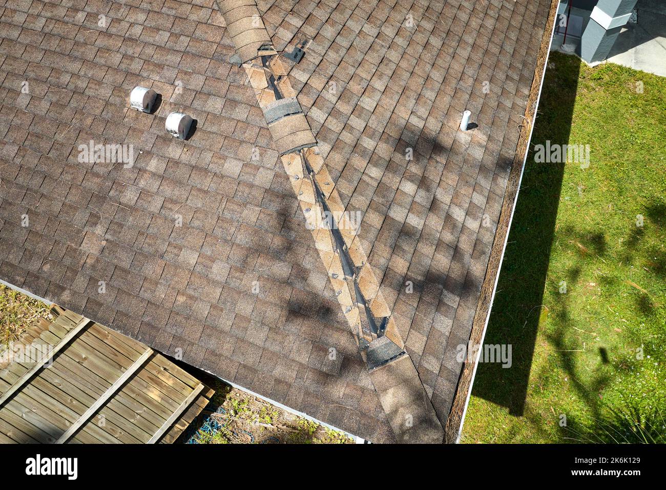 El viento dañó el techo de la casa con tejas de asfalto faltantes