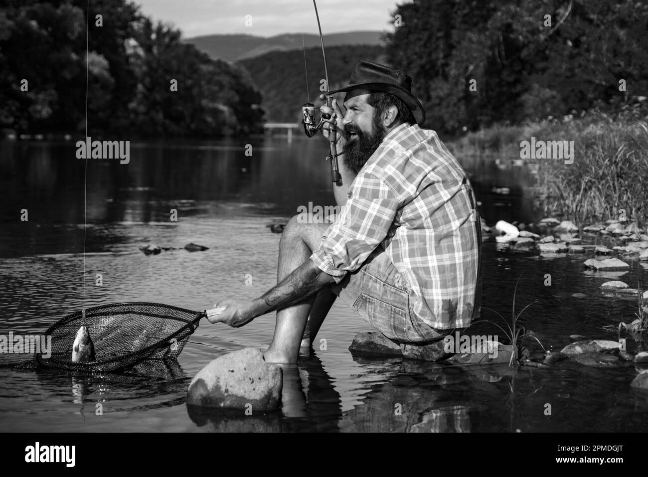 Pescador utilizando la pesca de caña en el río de montaña Un pescador