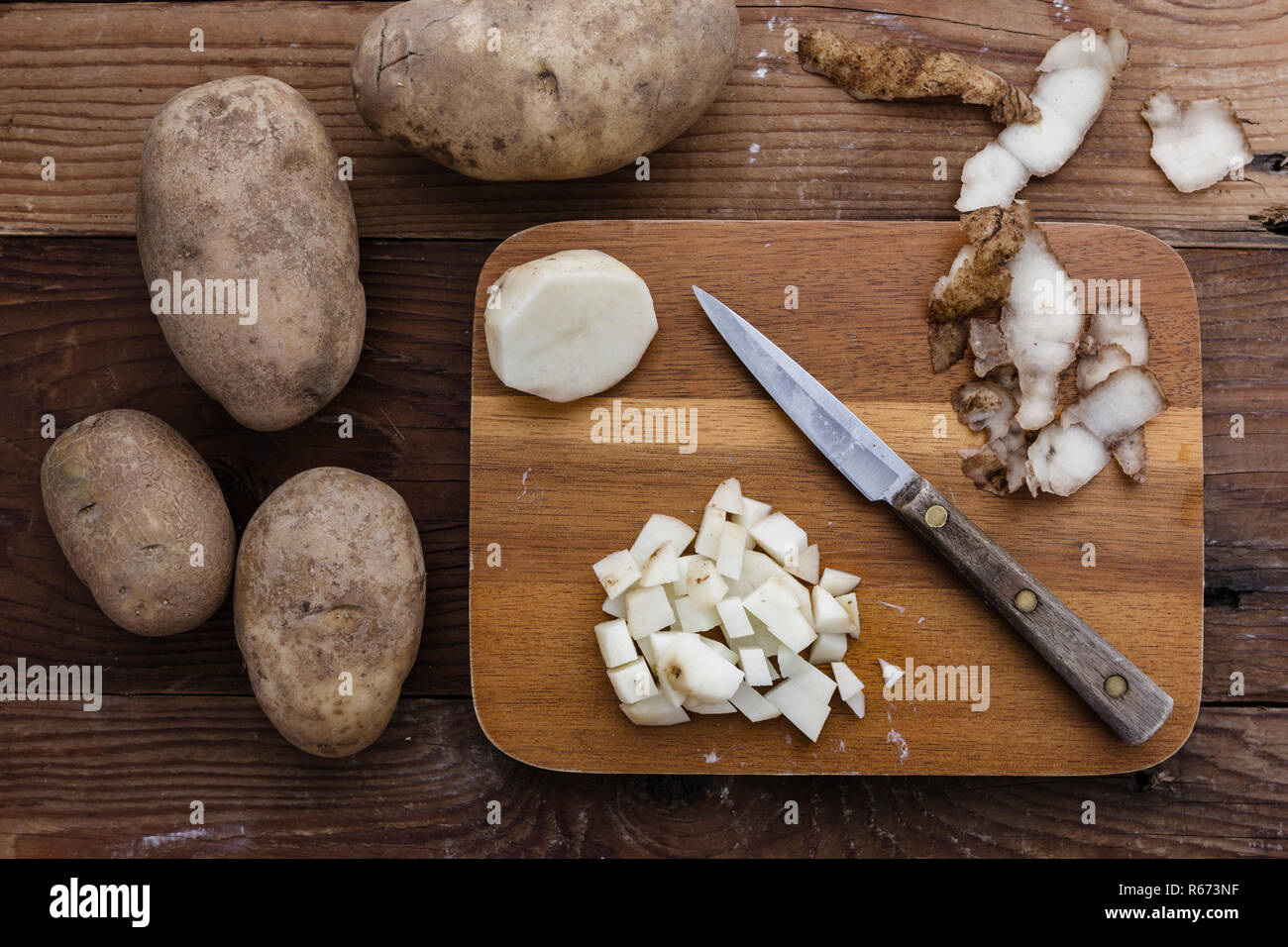 Una visión de conjunto y cortar las patatas en una tabla para cortar