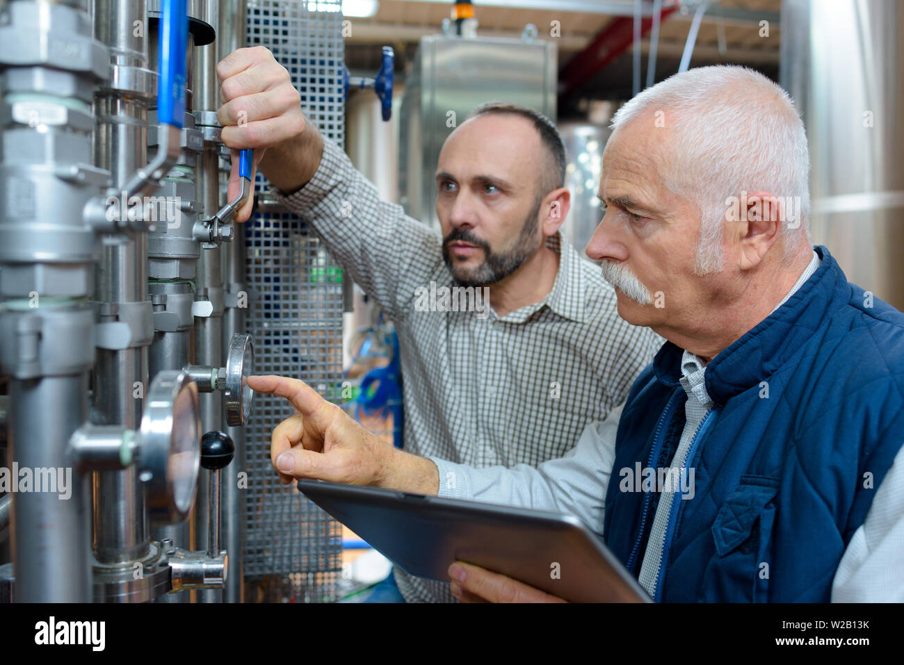 Cervecería trabajador técnico inspeccionando el tubo de presión