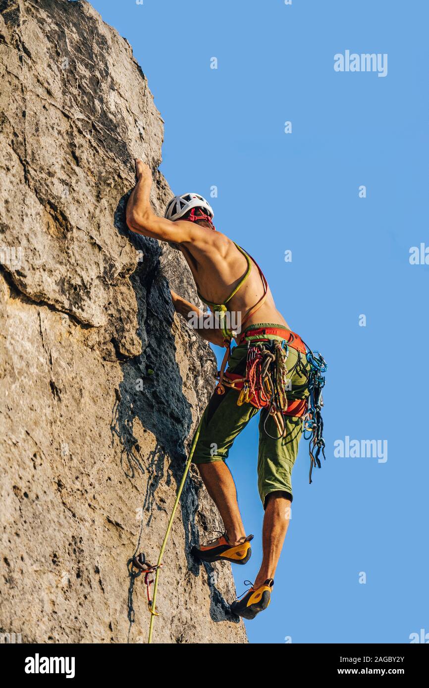 Plan vertical d un alpiniste grimpant les rochers à l aide de son