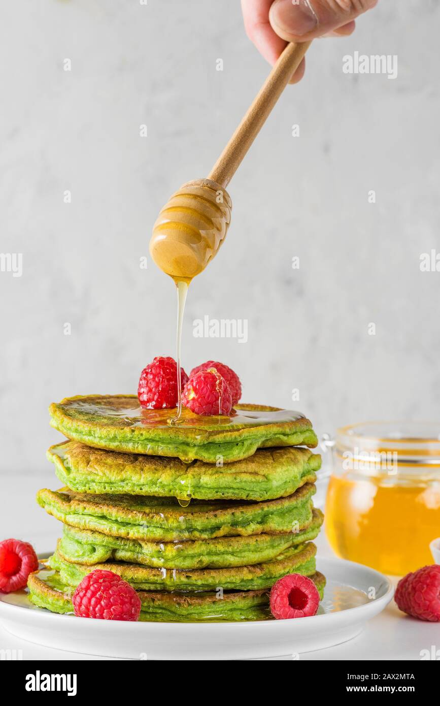 Crêpes vertes au thé de Matcha Pile de crêpes maison avec framboises