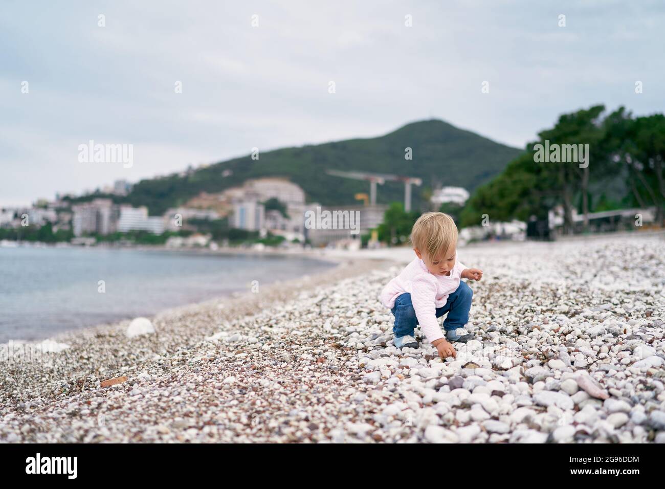 Petite Fille Accroupie Plage Banque De Photographies Et Dimages