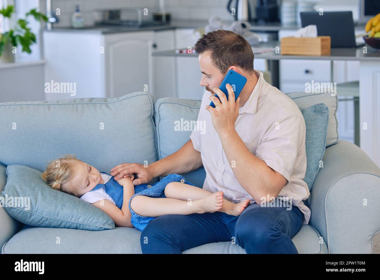 Petite fille malade couché sur le canapé tandis que papa utilise le