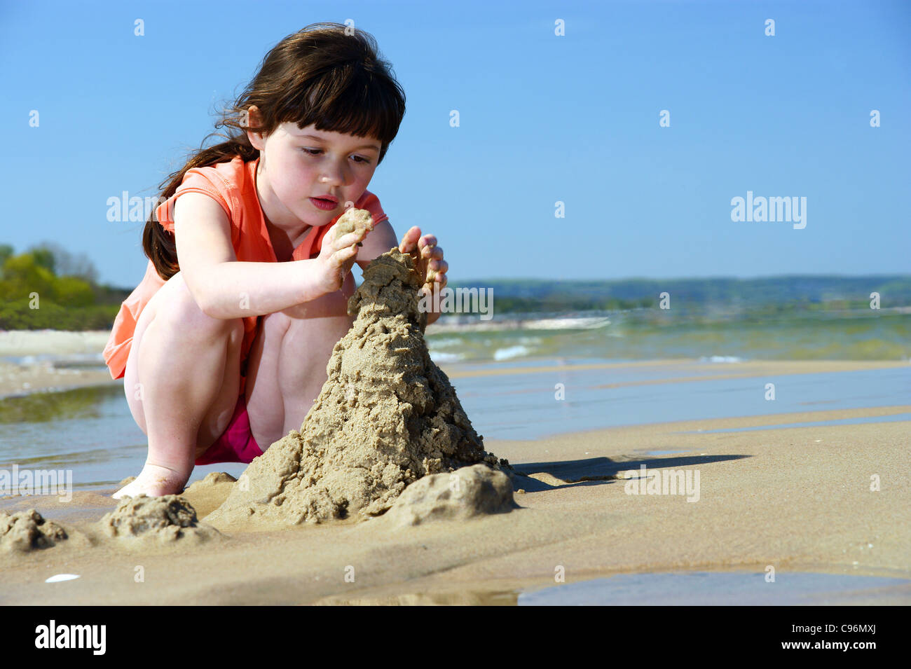 Les enfants sur la plage jeune fille jouant dans le sable à faire des