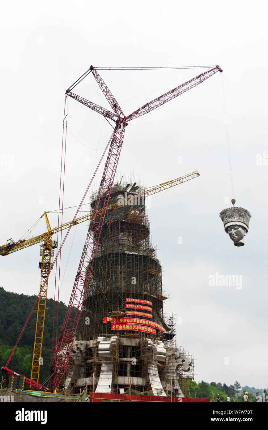 Une grue soulève la tête d une statue géante de Yang Asha la déesse de