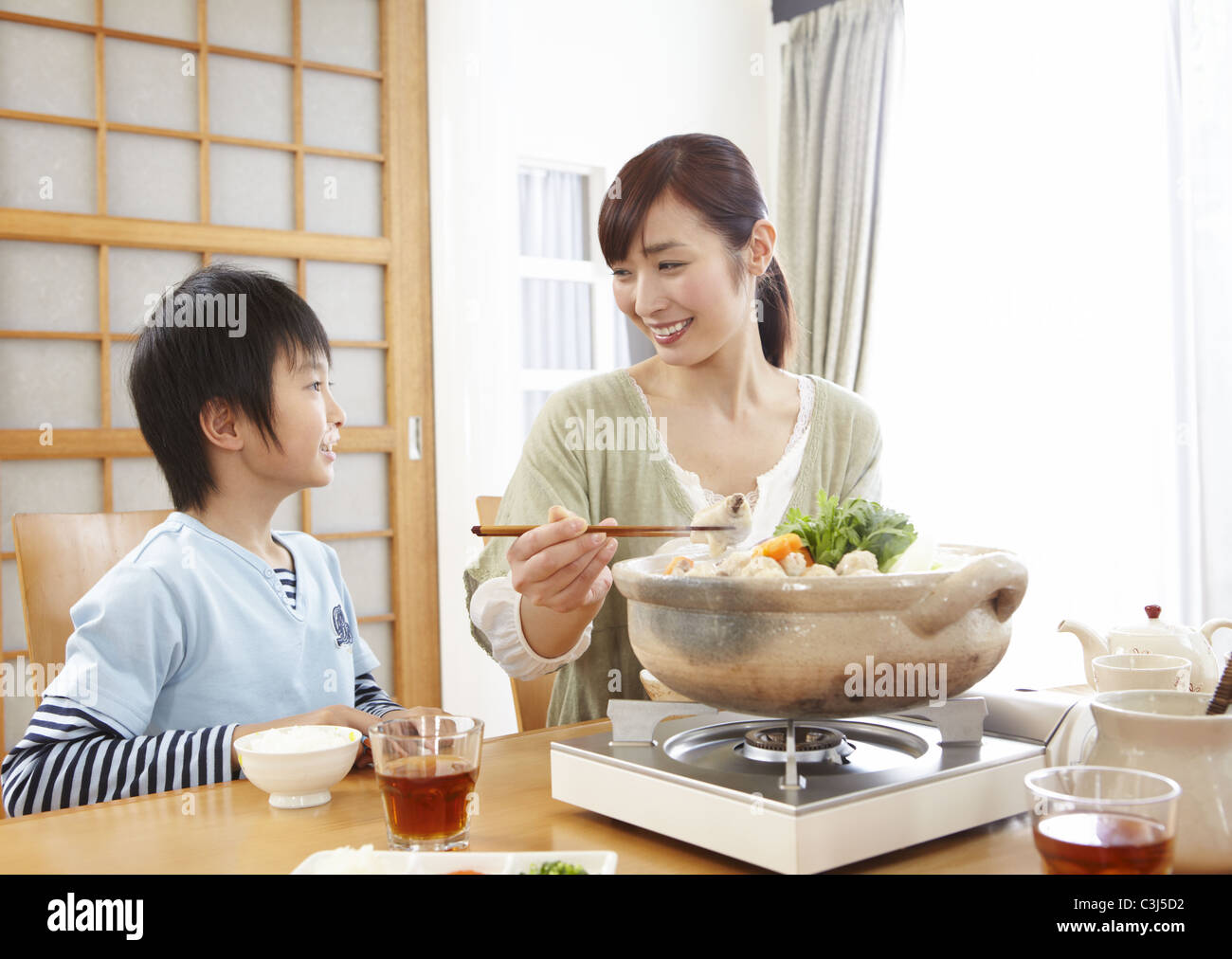Madre E Figlio Seduti Intorno Il Giapponese Hot Pot Foto Stock Alamy