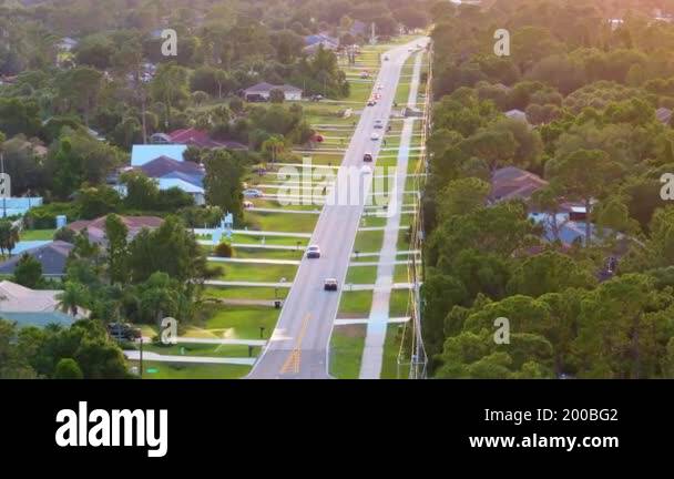 Rural road with driving traffic cars in American small town in Florida ...
