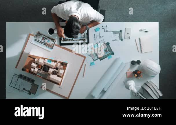 Top view of smart architect engineer looking house model and blueprint ...