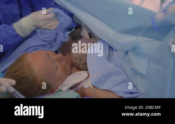 Born Operations A just-born baby is placed on the mothers chest as the surgeon ...