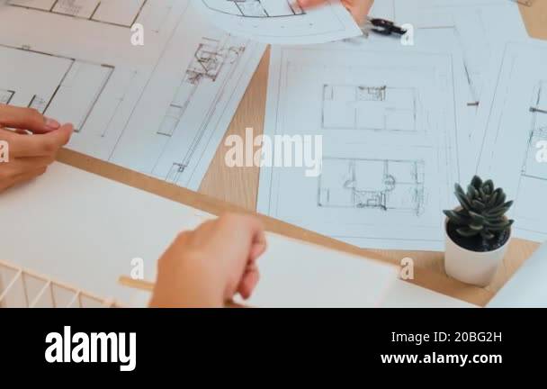 Interior designer drafting blueprint with customer supervise and ...