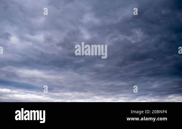 An overcast sky filled with cumulus clouds creates a moody and ...