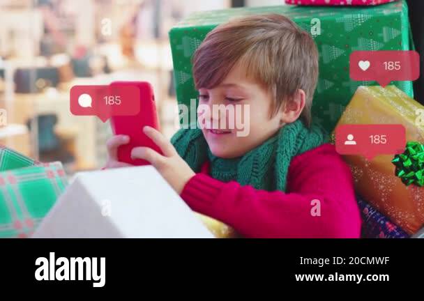 Close up boy sitting in shopping cart with Christmas present boxes in ...