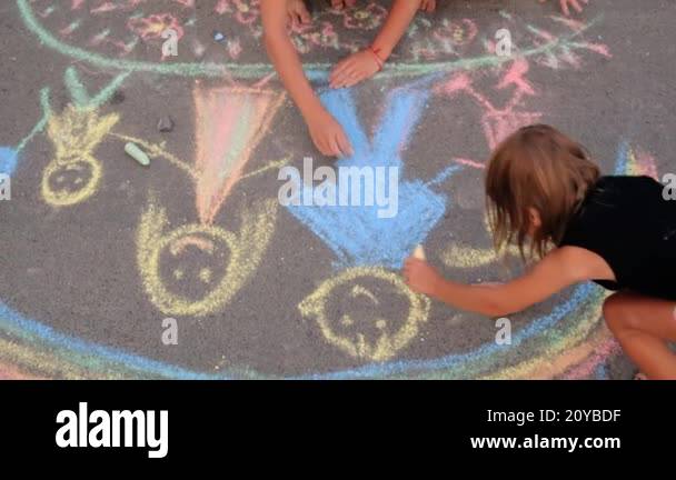 Children draw on the asphalt with chalk. Selective focus. Kid Stock ...