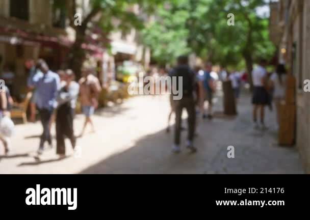 Blurred crowd walking in sunny outdoor street of mallorca with trees ...