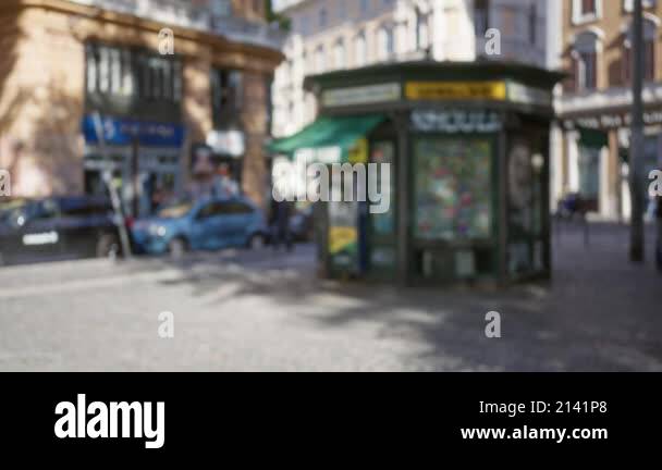 Blurred urban street scene featuring a kiosk in rome, italy with ...