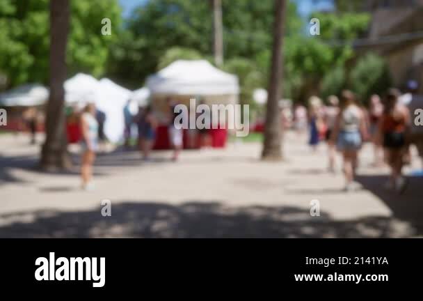 Outdoor market with blurred men and women in mallorca under trees and ...