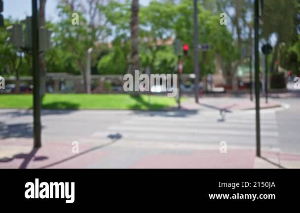Blurry outdoor street scene with defocused background, green trees ...