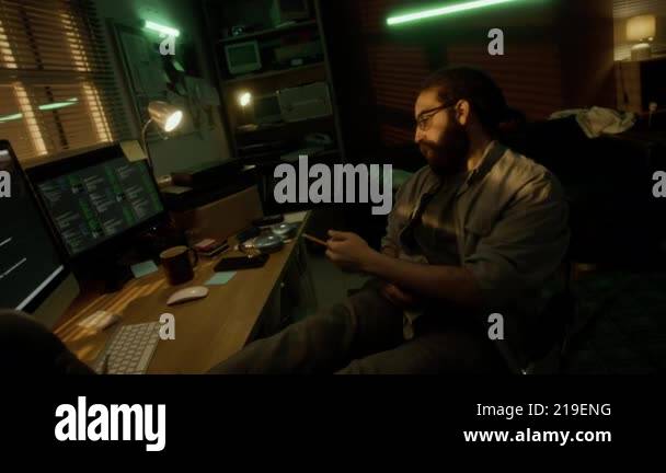 Relax Programmer Bearded programmer leaning back in chair with his feet up on desk ...
