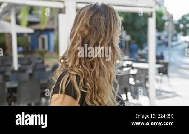 Young beautiful hispanic woman standing with serious expression at ...