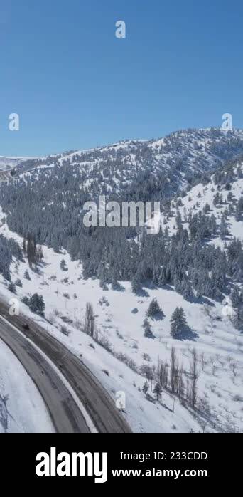 Drone View Of The Highway Passing Through The Snow-covered Mountain 