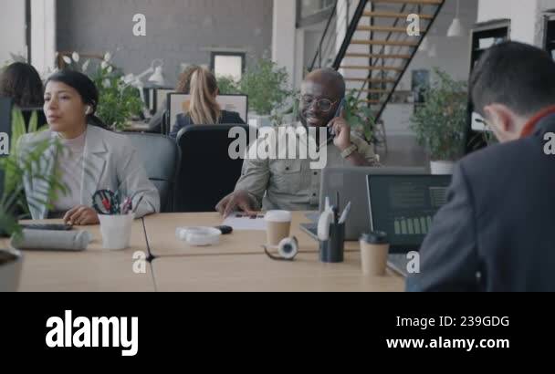 Multiethnic group of businesspeople working in office using computers ...
