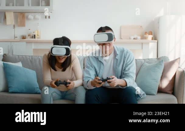 In a cozy living room, a young couple engages in a virtual reality ...