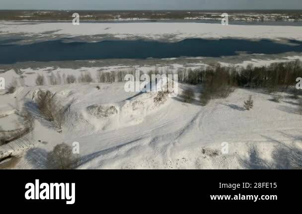 Sparse Snow A wintry scene featuring a snow covered hill, sparse trees, and a ...