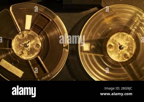 Close-up mesmerizing rotation of two reel-to-reel tapes on a vintage ...