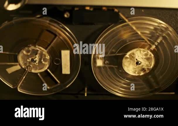 Top view of a vintage reel-to-reel tape recorder in action. The video ...