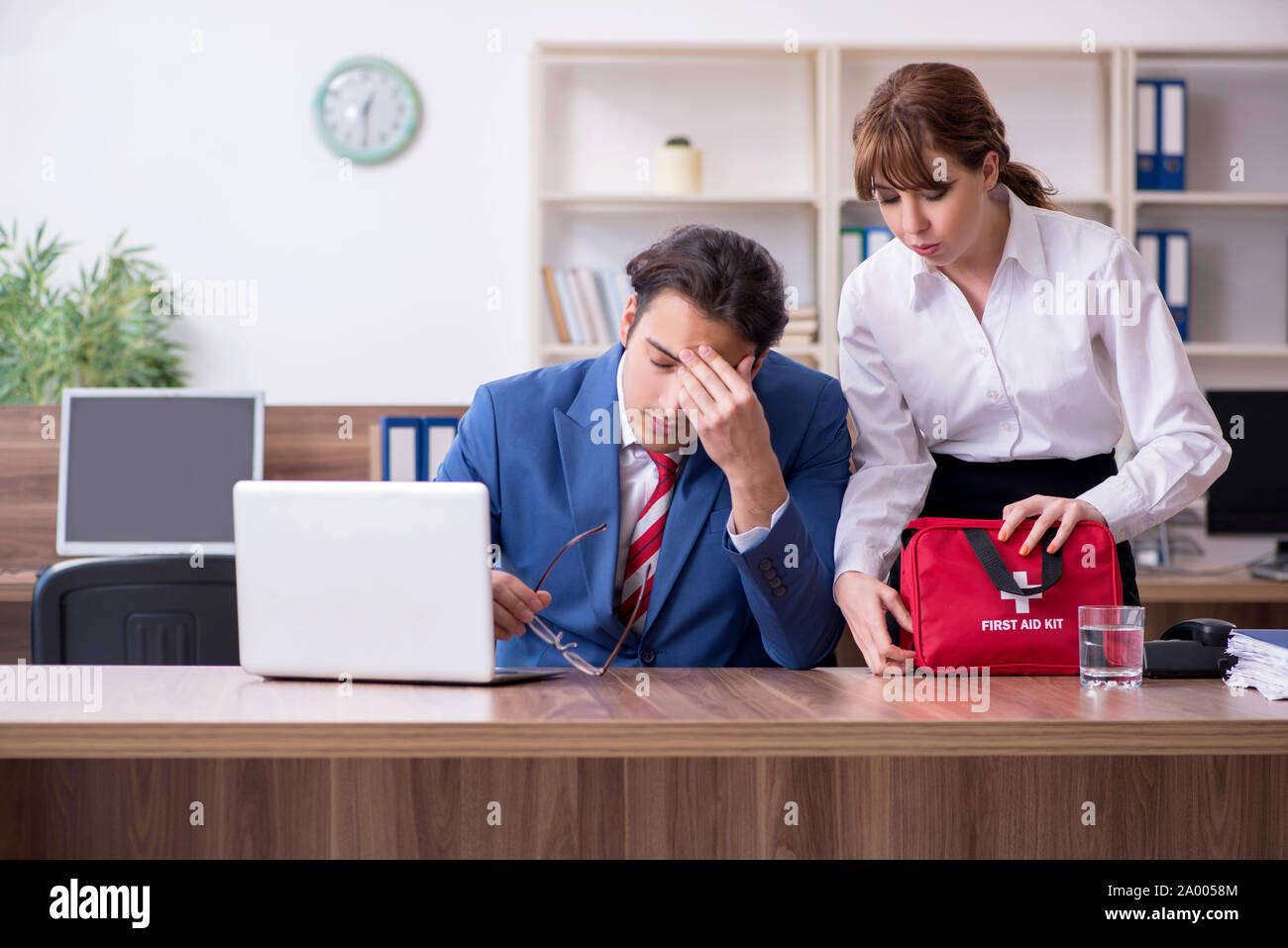 Employee receiving first aid in office Stock Photo - Alamy