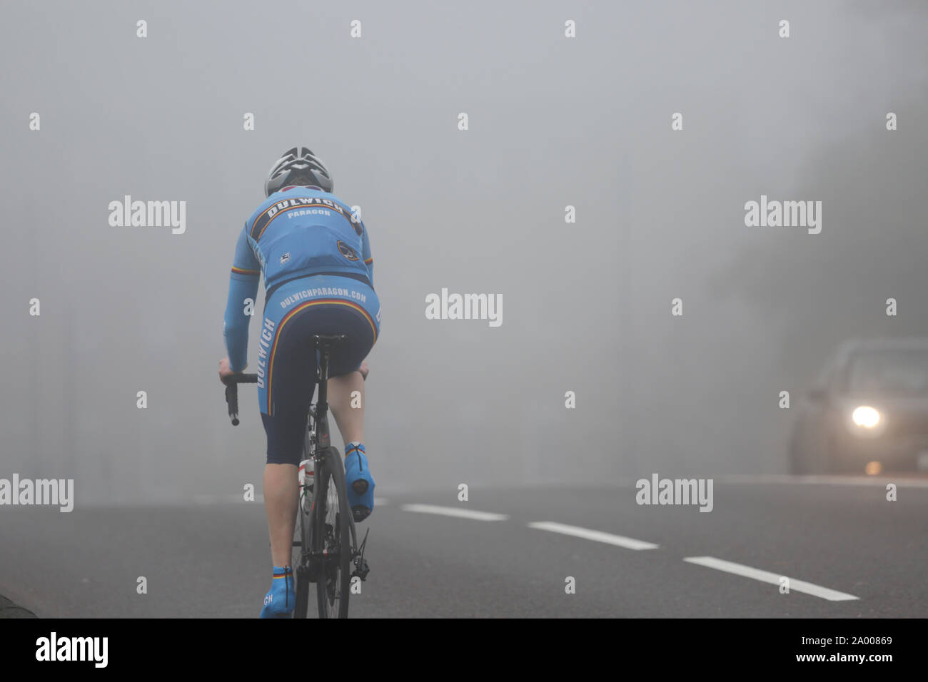 Cyclists riding, bicycle commuters, in heavy fog, a cold bad weather day. Stock Photo