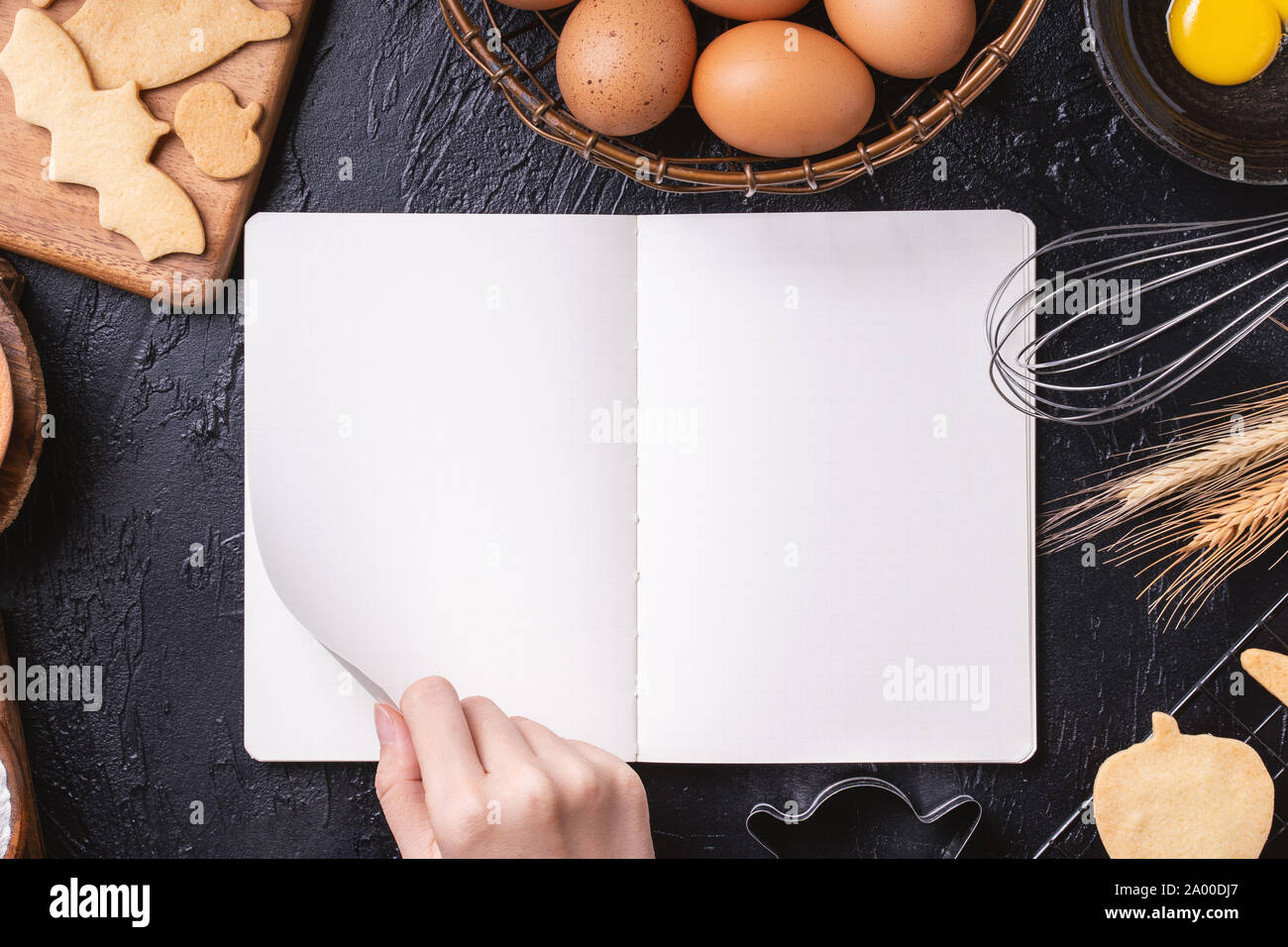 https://c8.alamy.com/comp/2A00DJ7/woman-is-reading-cookbook-recipe-of-making-halloween-cookies-with-baking-ingredients-design-concept-of-cooking-class-top-view-flat-lay-overhead-2A00DJ7.jpg