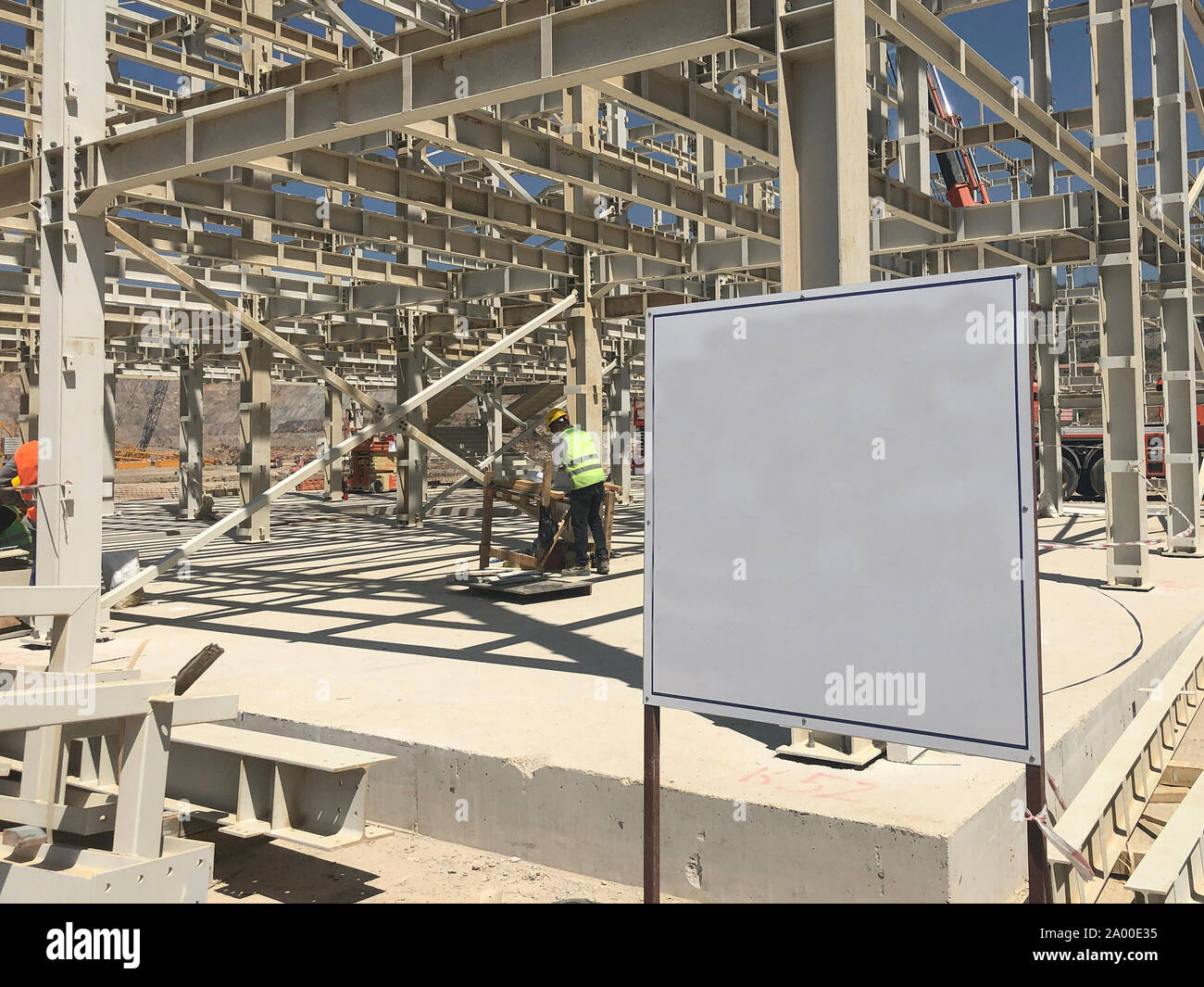 Object under construction stand at the construction site. Blank display board against prefabricated multi-storey building at the background Stock Photo