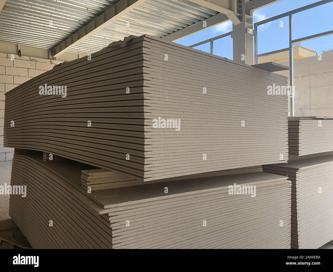 Piled sheets of drywall at the construction site. Stacked plasterboard