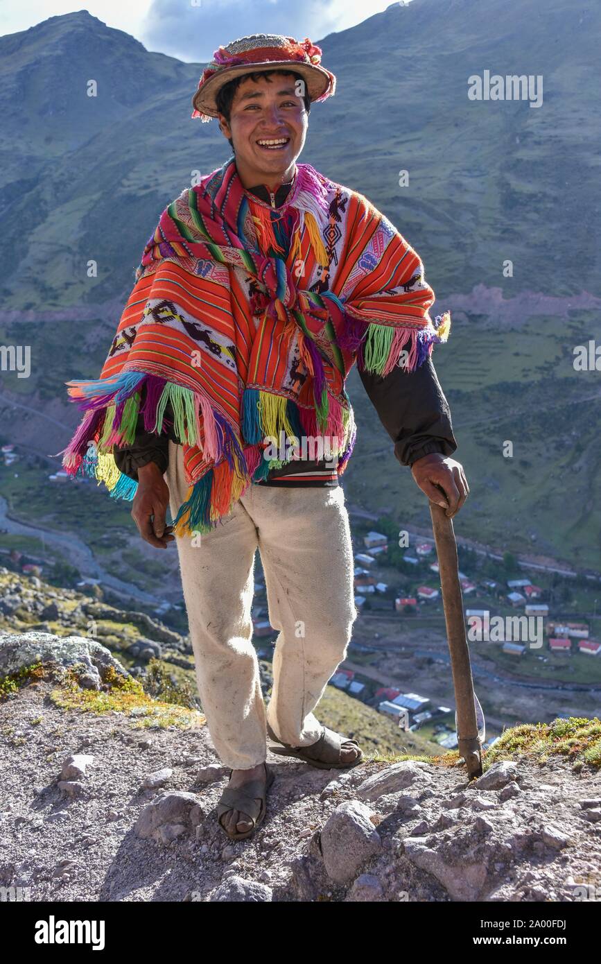 Indio mountain guide with hat and poncho in the Andes, near Cusco, Peru Stock Photo
