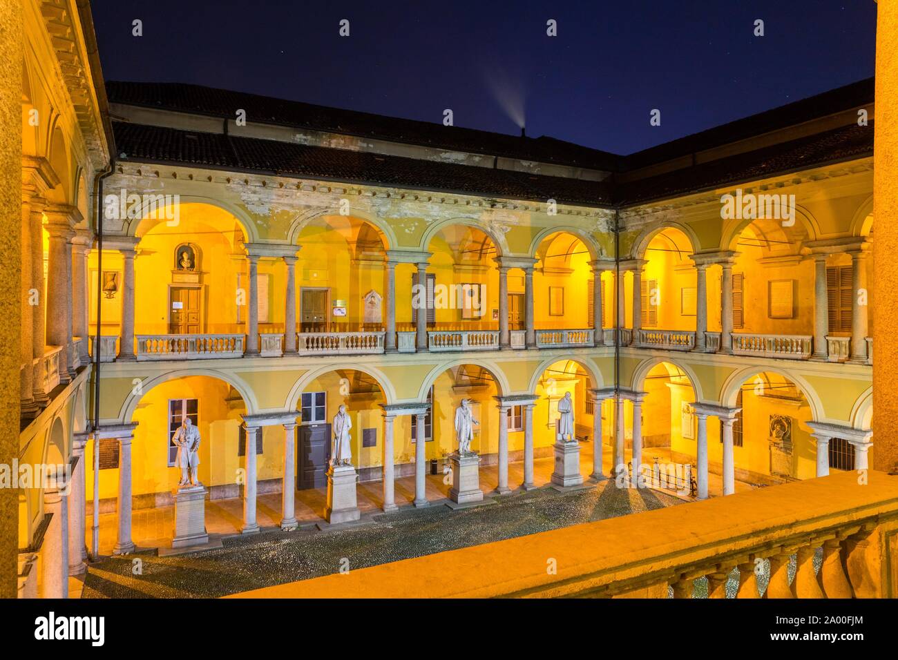 Illuminated courtyard with loggia and sculptures, University of Pavia, night scene, Pavia, Lombardy, Italy Stock Photo