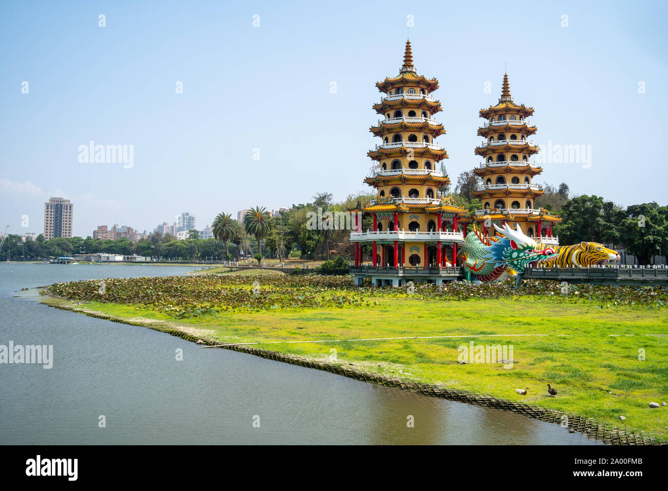 Kaohsiung, Taiwan: Tiger and Dragon Pagodas with green grass and Lotus in the front. Located at Lotus Pond in Zuoying district, Kaohsiung Stock Photo