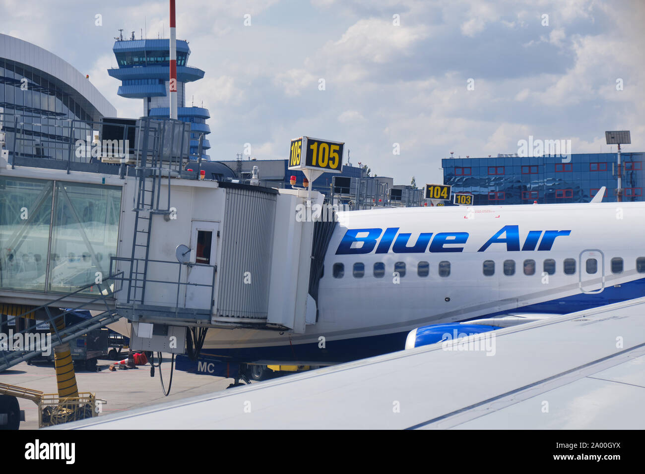 Otopeni, Romania - September 11, 2019: Blue Air plane connected to a passenger boarding bridge at Henri Coanda International Airport, near Bucharest, Stock Photo