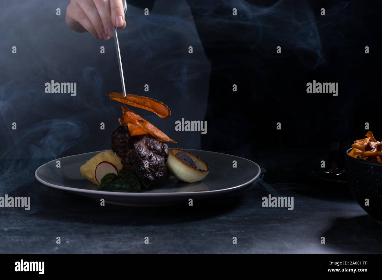 Steak dish served in a dark and smoky environment Stock Photo