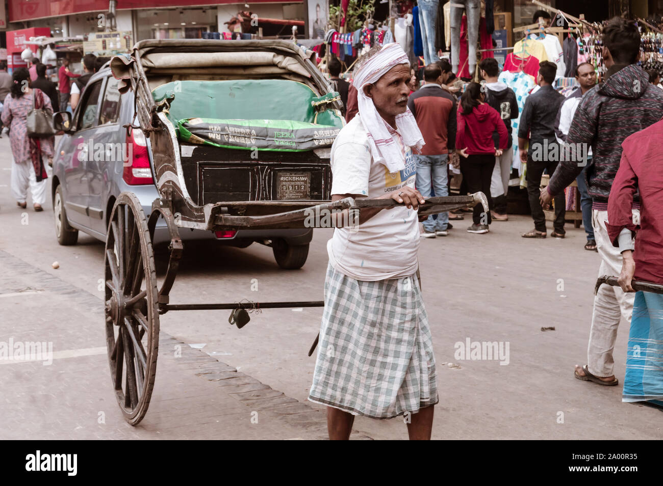 Kolkata, India 1 May, 2019 – A traditional tanga-wala rickshaw puller (human-drawn carriage driver) in city street of Kolkata at noon in summer months Stock Photo